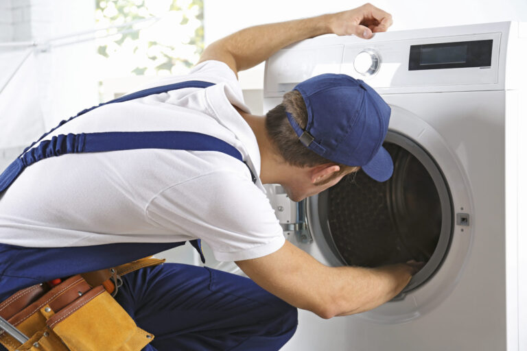 Plumber repairing washing machine